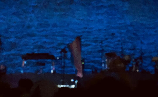 A transgender pride flag hanging off of the mic stand at a Hozier concert.